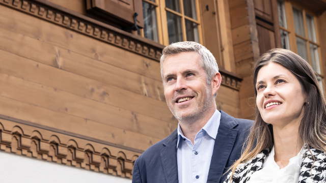 Mann und Frau stehen vor Chalet